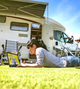 Woman singing up to Kiwi Fuelcards in front of a campervan